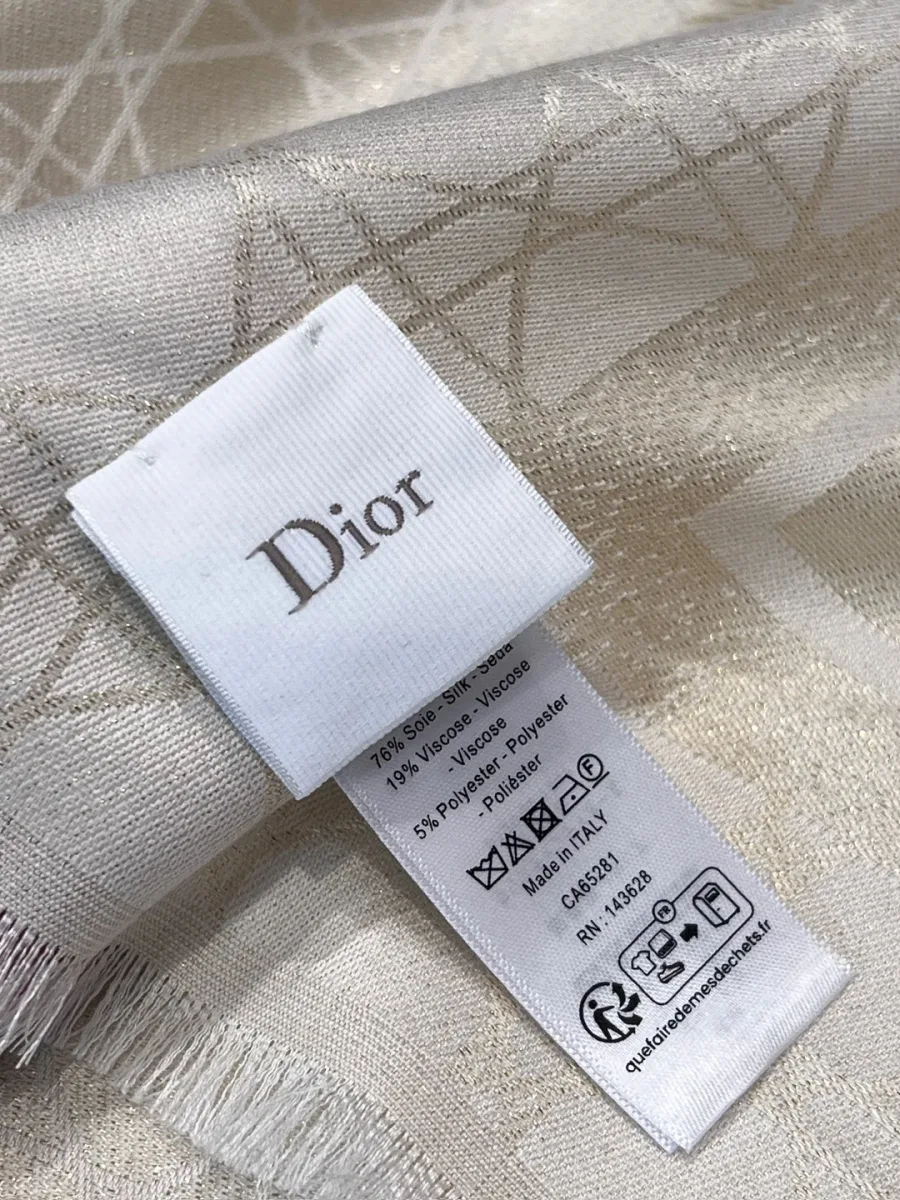 Фирменная бирка Dior на светлой ткани с бахромой