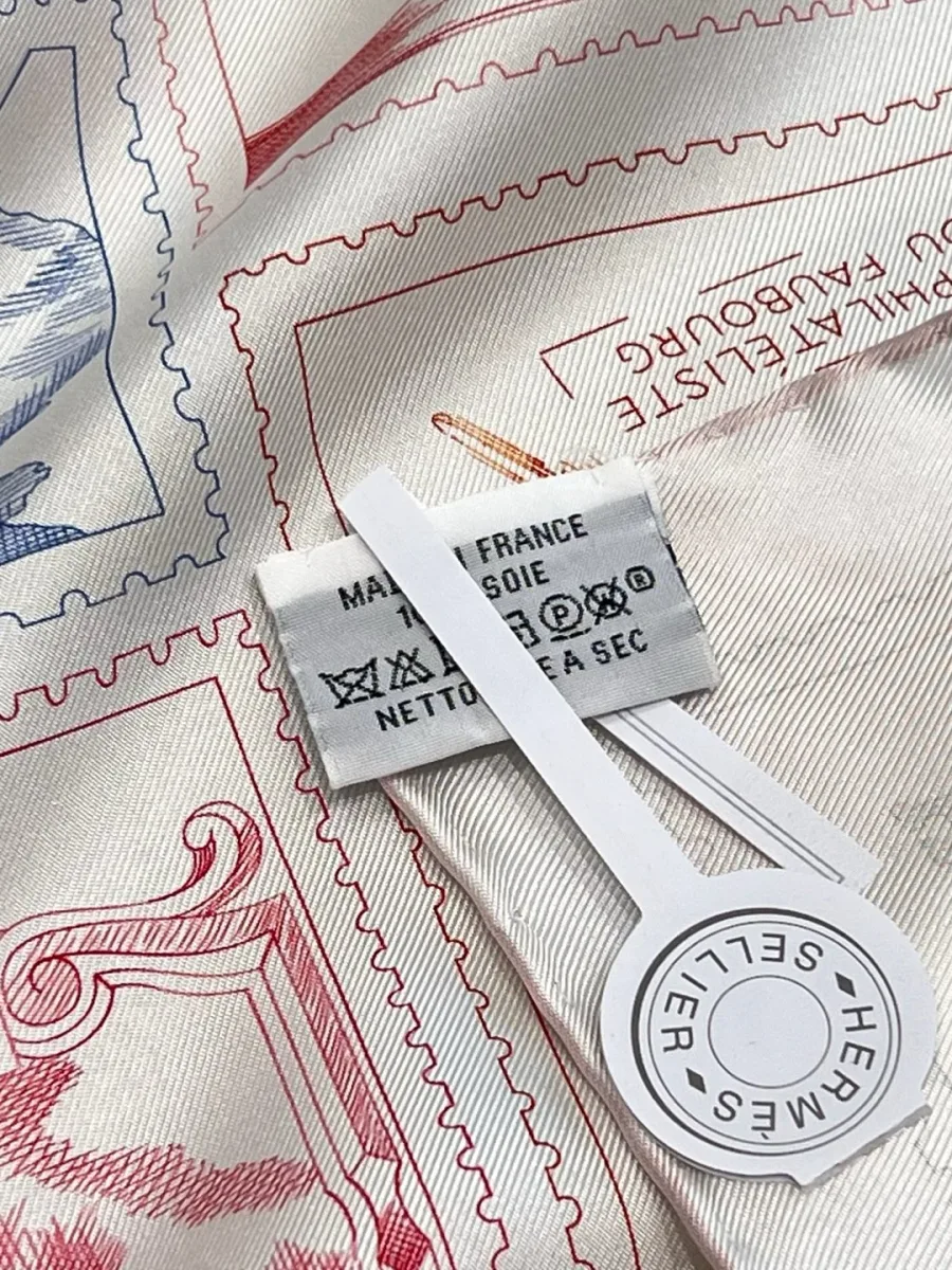 Детализация шёлкового твила платка Hermes с ярлыком и биркой