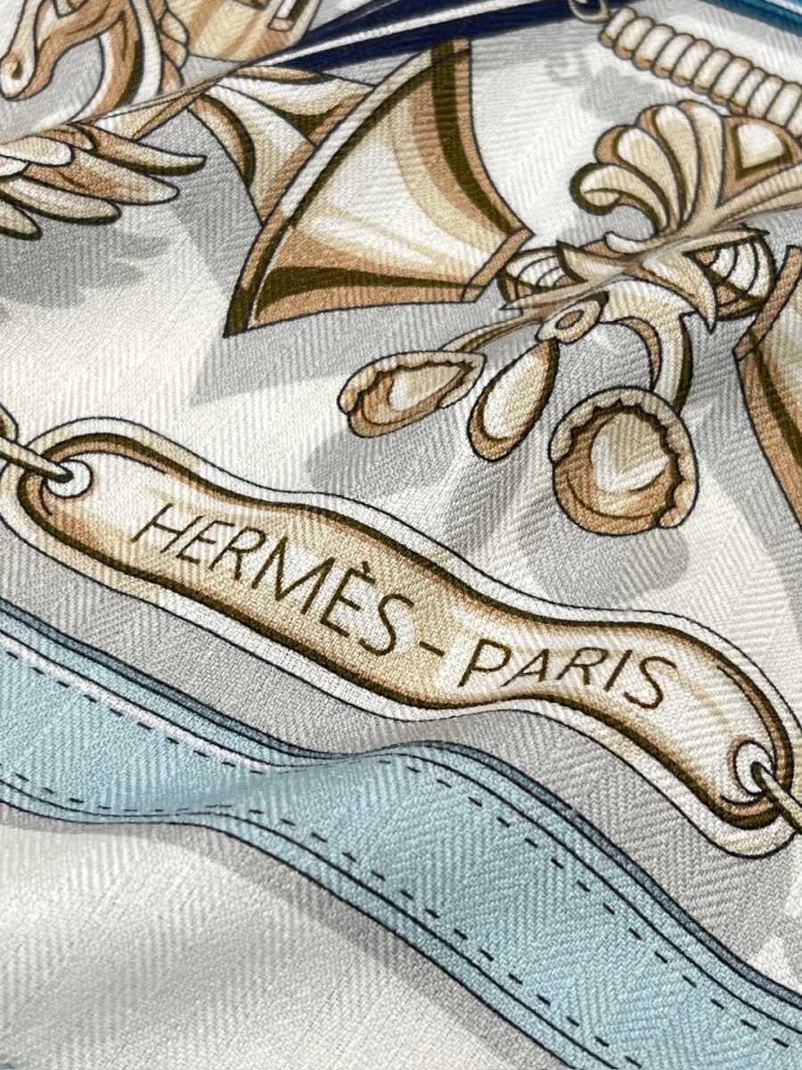 Крупный план надписи Hermes Paris и элементов орнамента на ткани