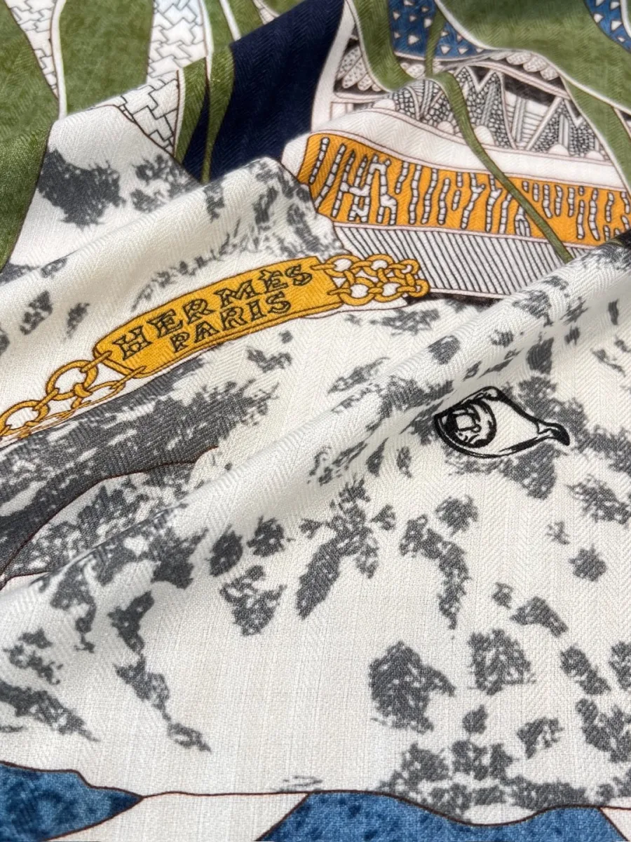 Крупный план полотна шали с фирменным логотипом Hermes Paris и рисунком