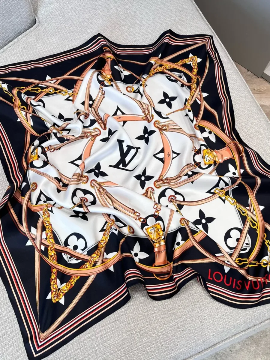 Шёлковый платок с узором Monogram и цепочками, разложенный на диване