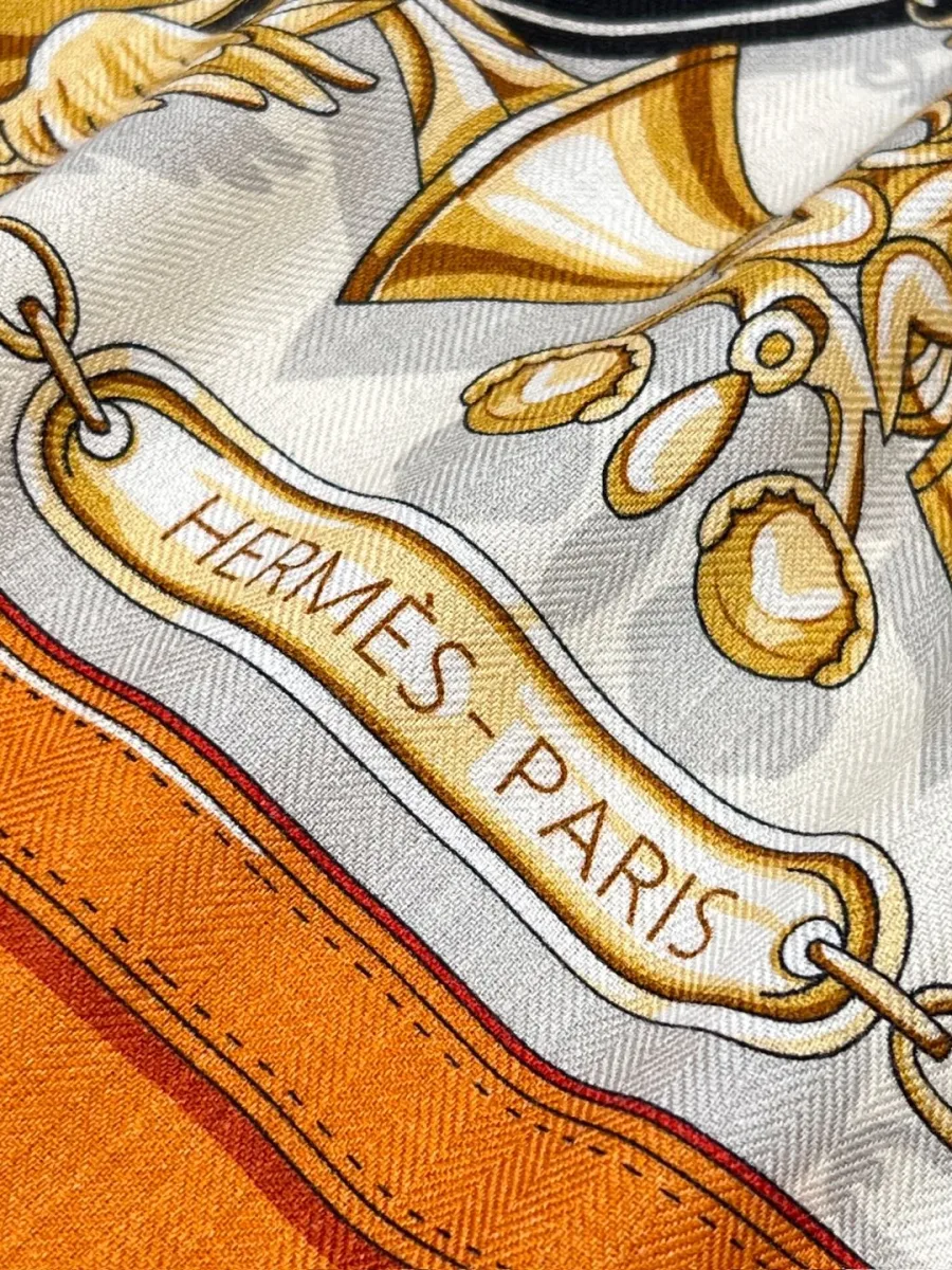 Крупный план фактуры ткани с надписью Hermes Paris