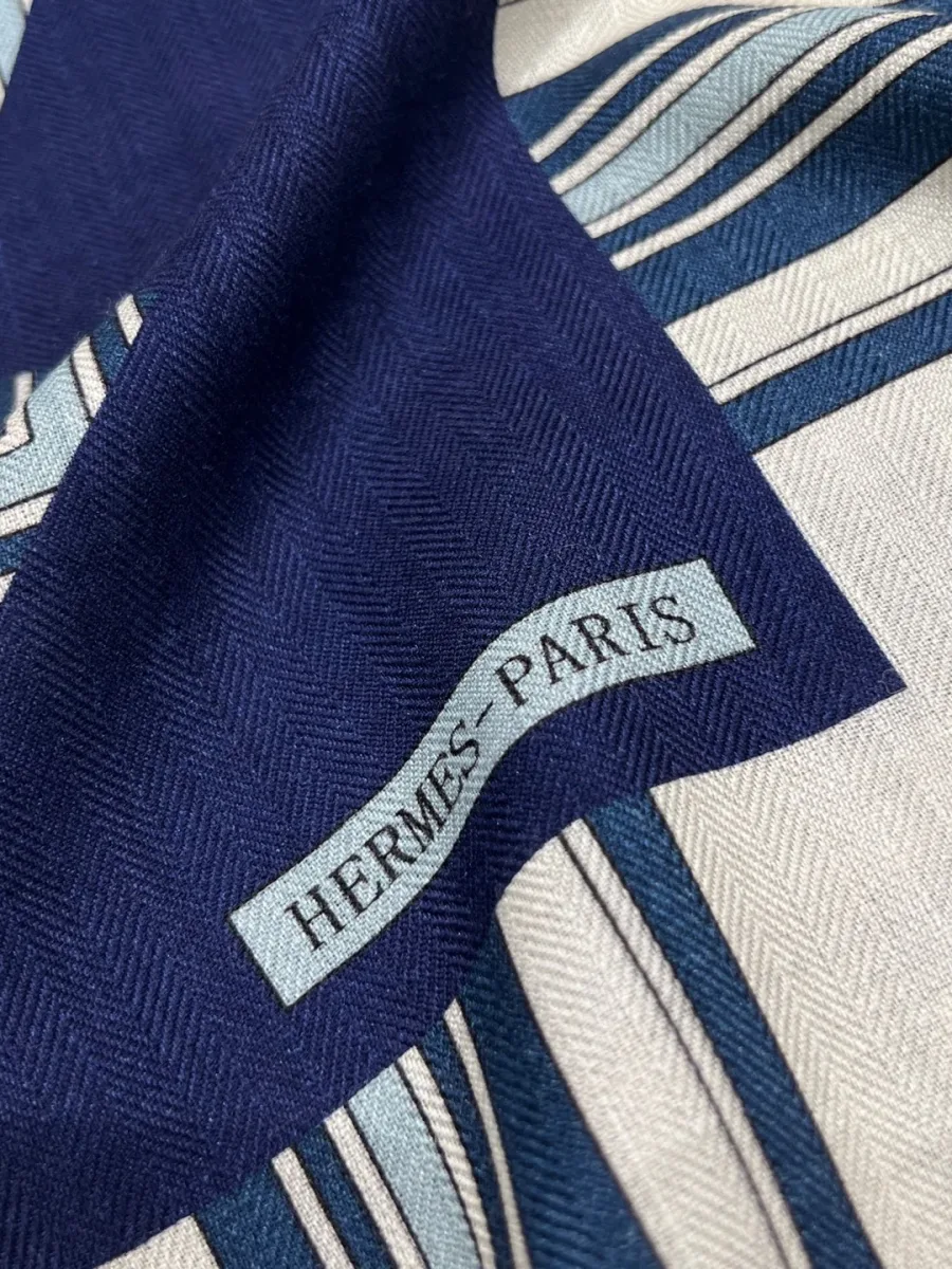 Крупный план фактуры ткани шали с надписью Hermes Paris