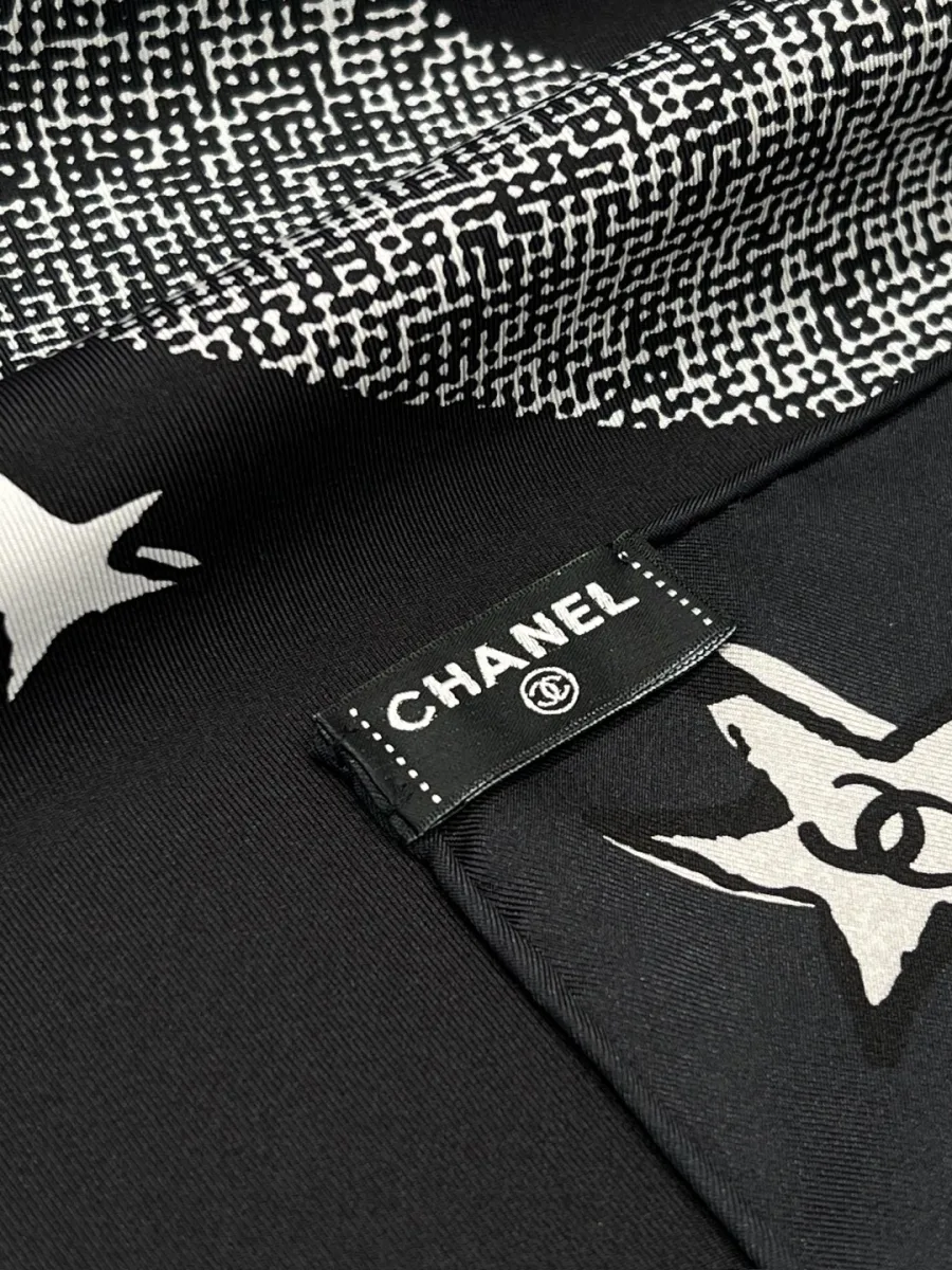 Крупный план края платка с ручной подшивкой и тканевой биркой Chanel