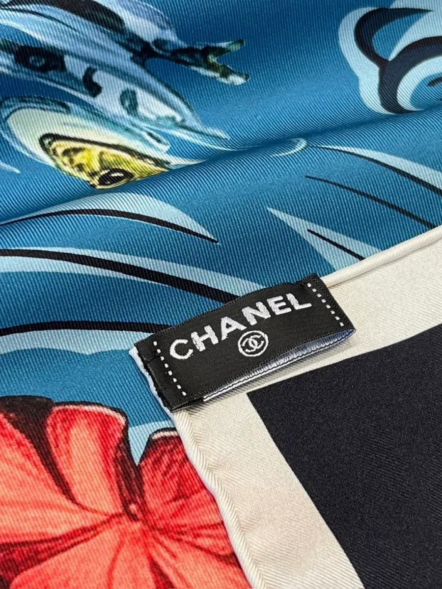 Крупный план обработанного края платка с текстильной фирменной биркой Chanel