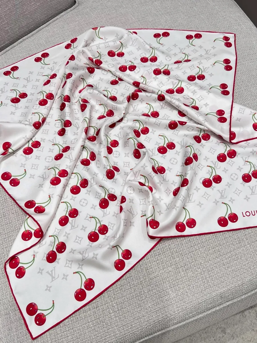 Белый шёлковый платок с узором Monogram Cerises, разложенный на диване