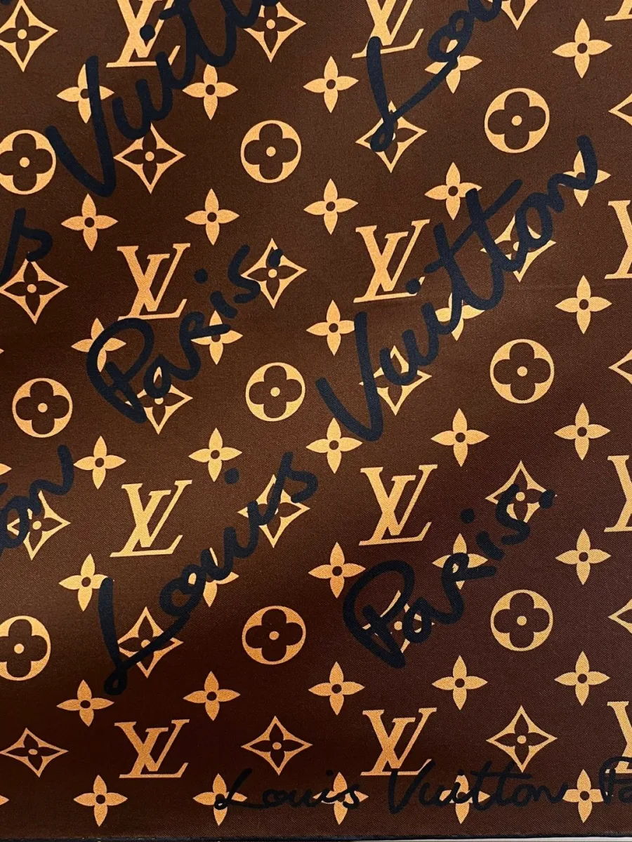 Фактура шёлкового твила с узором Monogram и каллиграфической надписью, крупный план