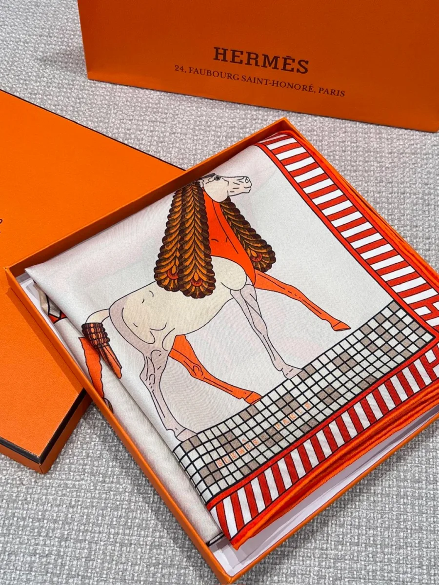 Шёлковый платок Hermes Toute Allure, аккуратно сложенный в оранжевой коробке