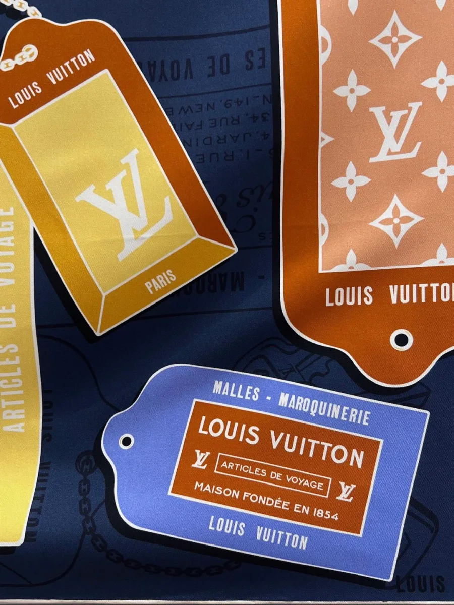 Крупный план принта с изображением багажных бирок Louis Vuitton на тёмно-синем фоне