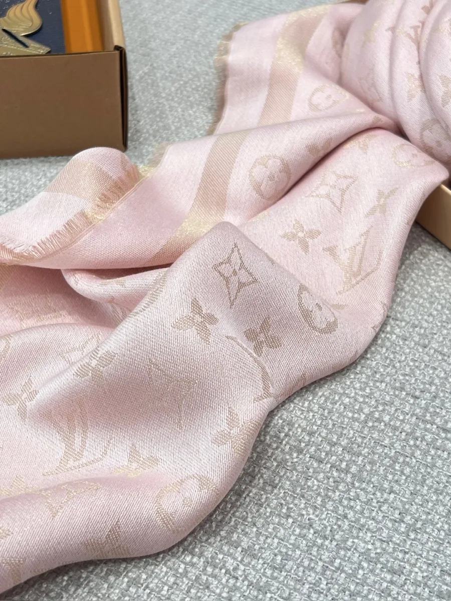 Розовая шаль с узором Monogram в сложенном виде рядом с подарочной коробкой