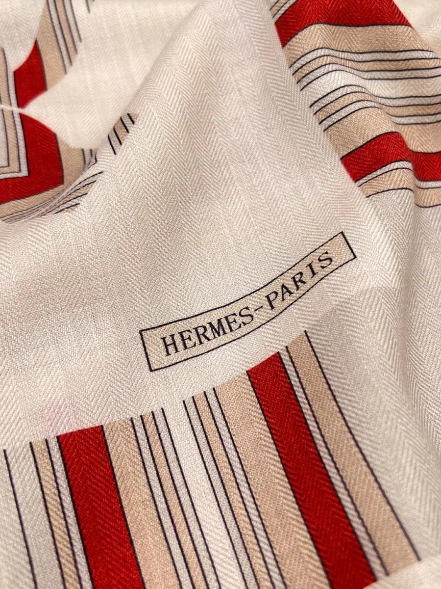 Крупный план угла шали с полосатой каймой и надписью Hermes-Paris