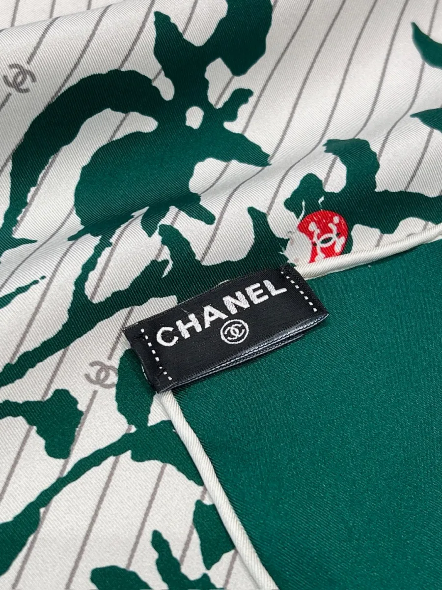 Крупный план угла платка с фирменной тканевой биркой Chanel и подшитым краем