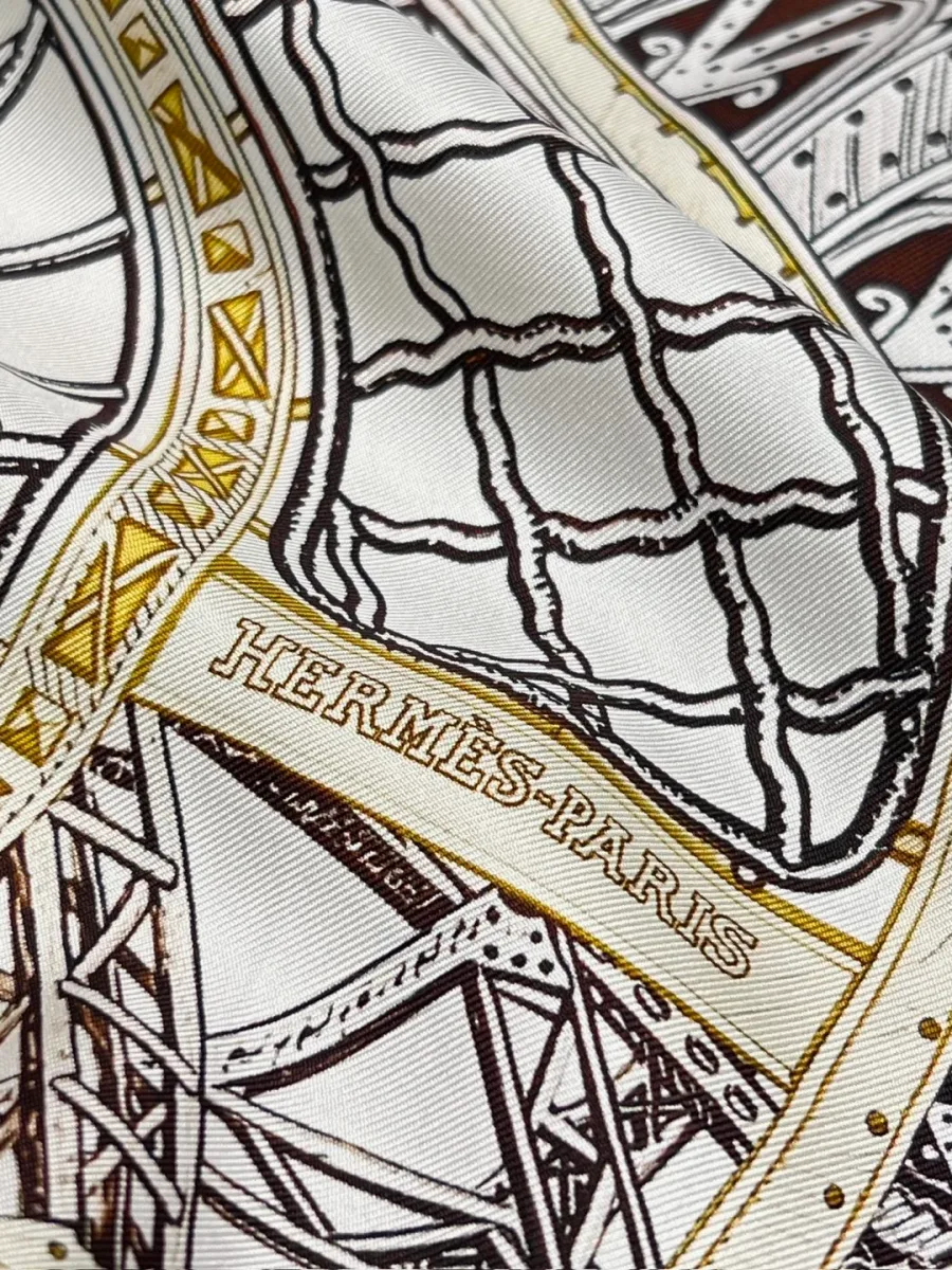 Фрагмент шелкового платка с надписью Hermes-Paris и графичным узором, крупный план
