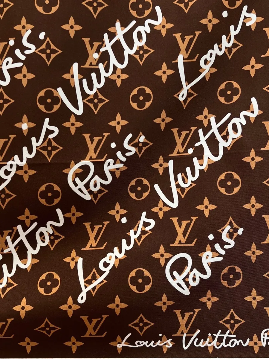 Крупный план узора с монограммой и рукописным текстом Louis Vuitton Paris