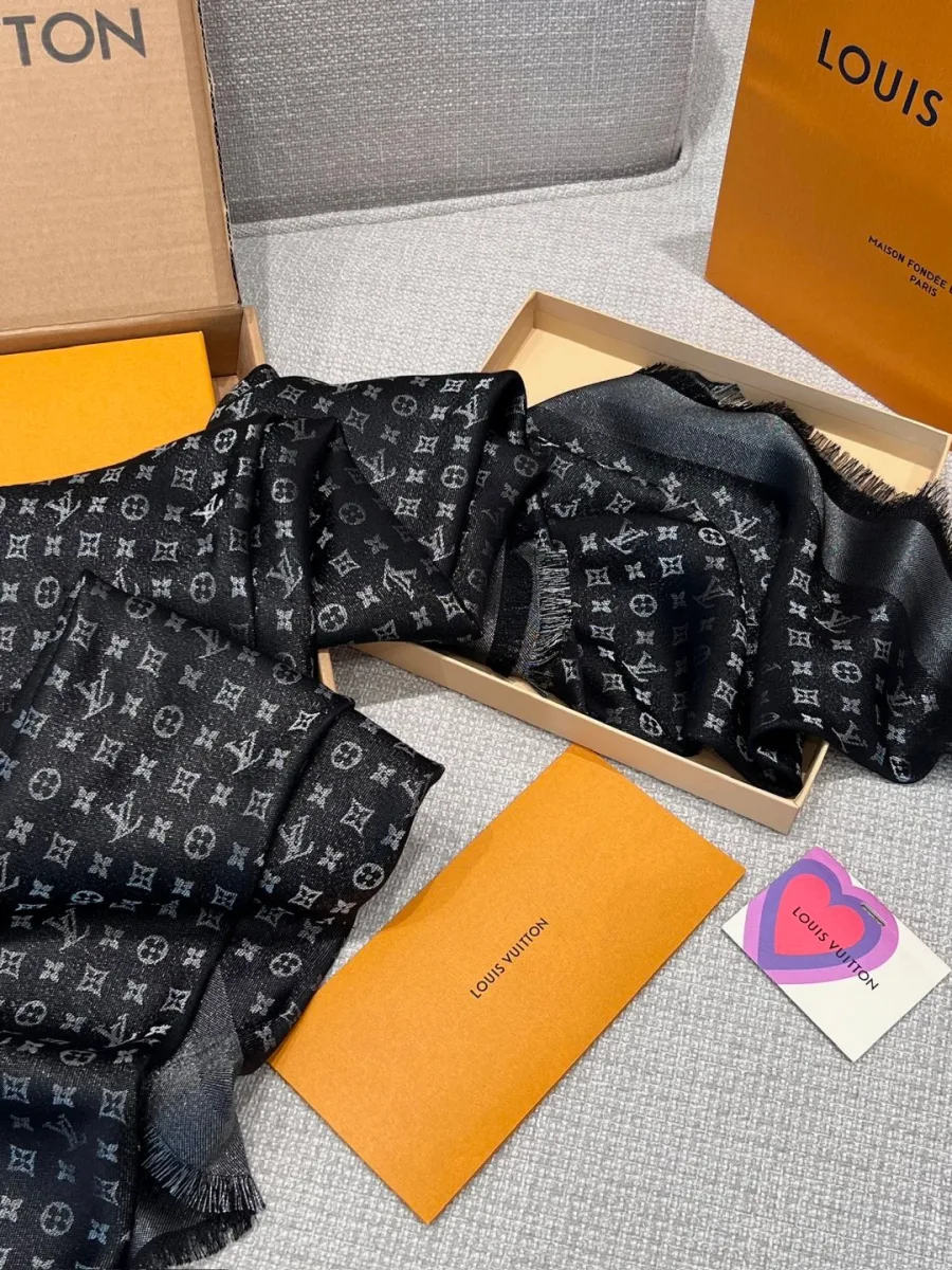 Чёрная шаль с узором Monogram в разложенном виде рядом с фирменной коробкой