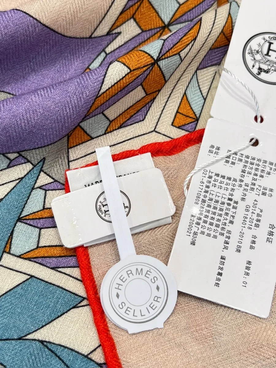 Крупный план принта шали Hermes, рулика и фирменных навесных бирок