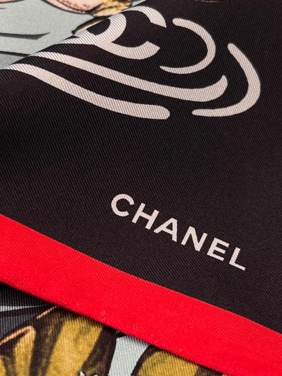 Крупный план чёрного уголка платка с белой надписью Chanel