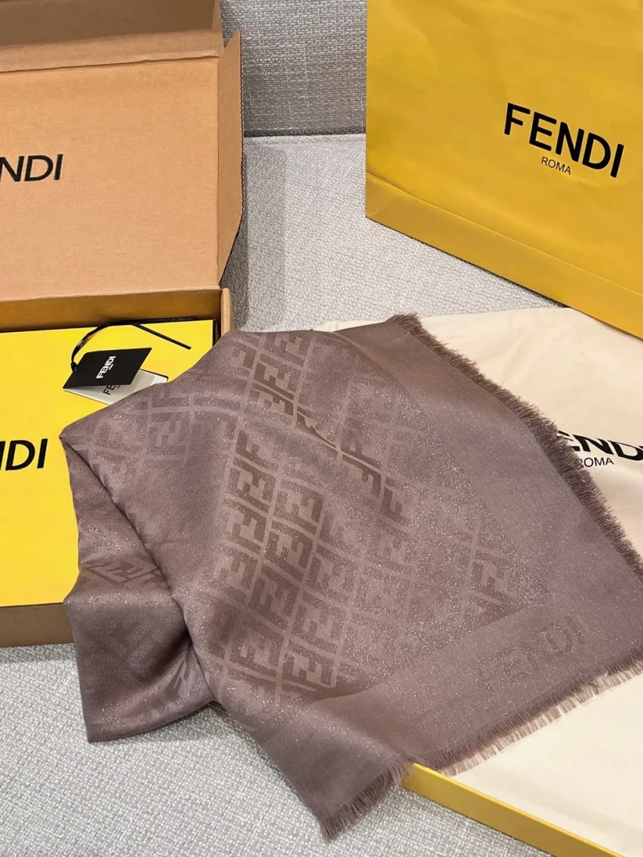 Сложенная серая шаль с узором FF рядом с подарочной коробкой Fendi