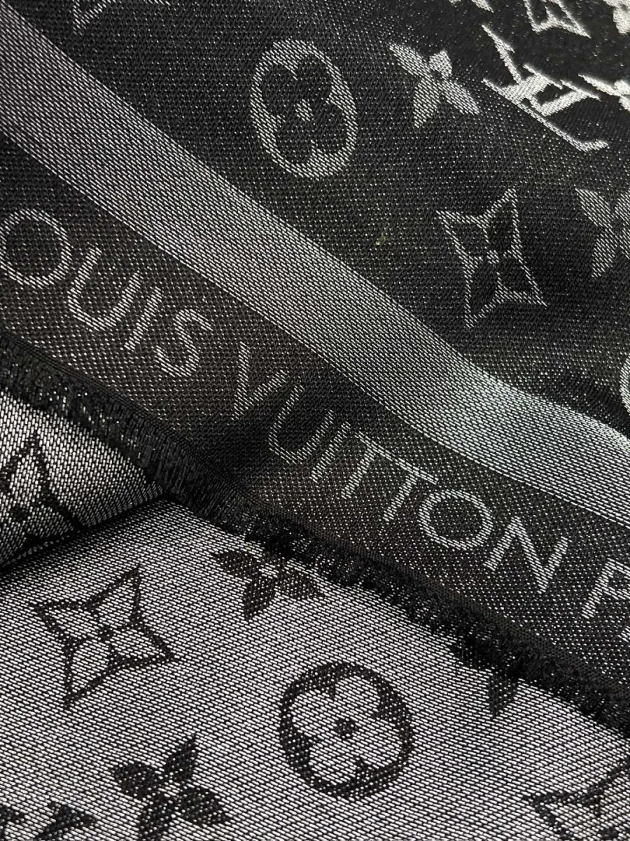 Крупный план жаккардовой ткани с люрексом и надписью Louis Vuitton Paris