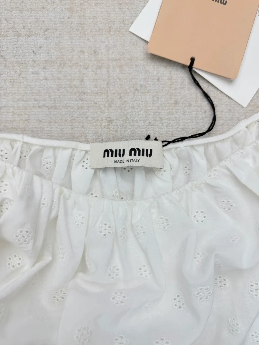Крупный план пояса со сборками и фирменной бирки Miu Miu