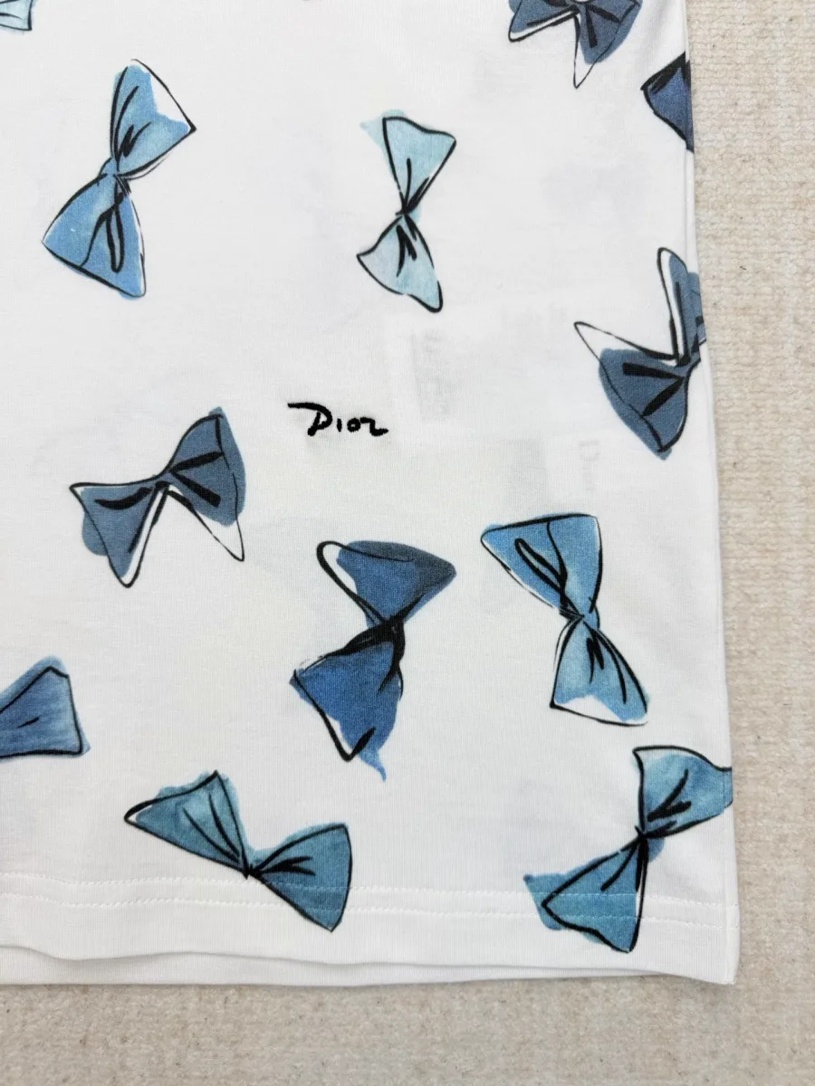 Крупный план графического принта в виде синих бантов и надписи Dior