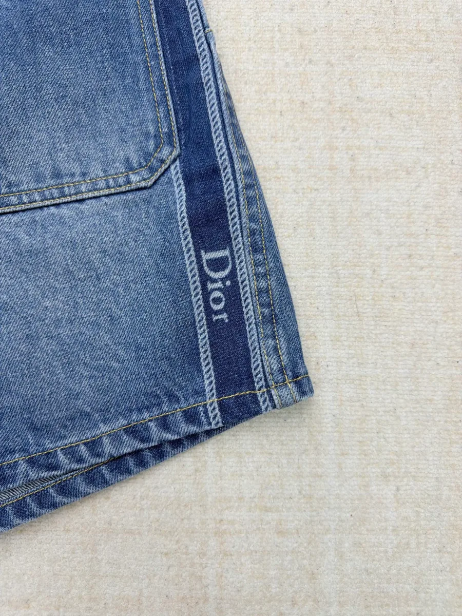 Крупный план вышитого логотипа Dior на боковом лампасе шорт