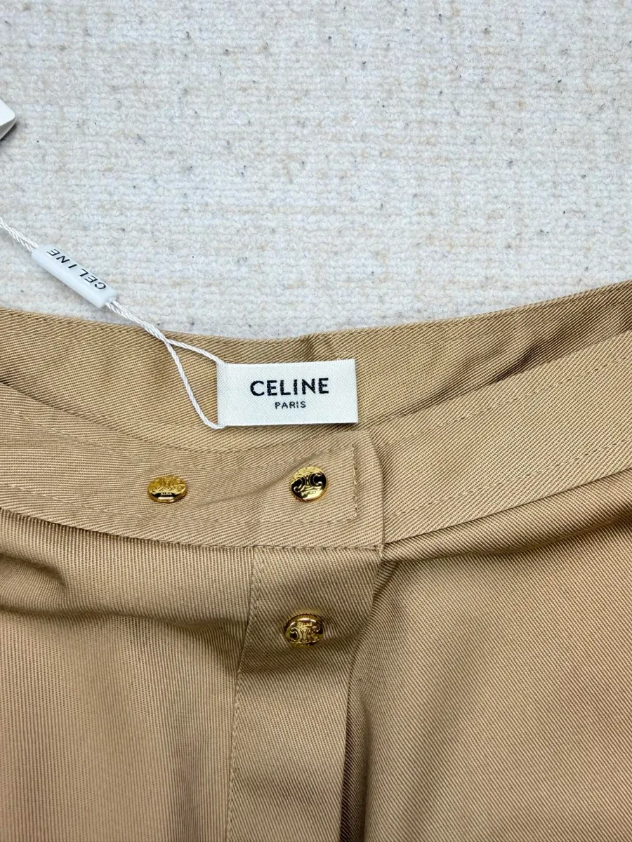 Крупный план пояса и бирки Celine бежевой юбки с золотистыми брендированными кнопками