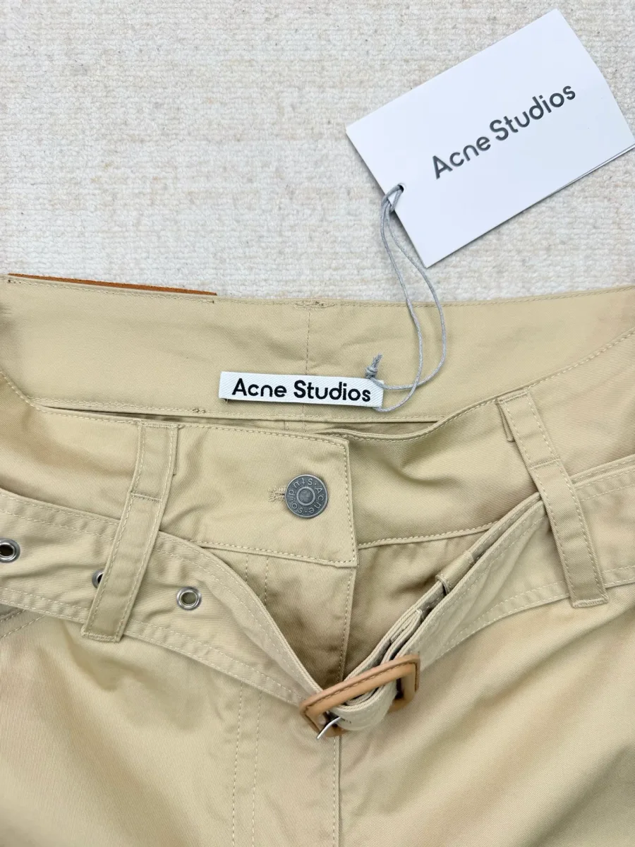 Поясная зона брюк в расстёгнутом виде с биркой Acne Studios