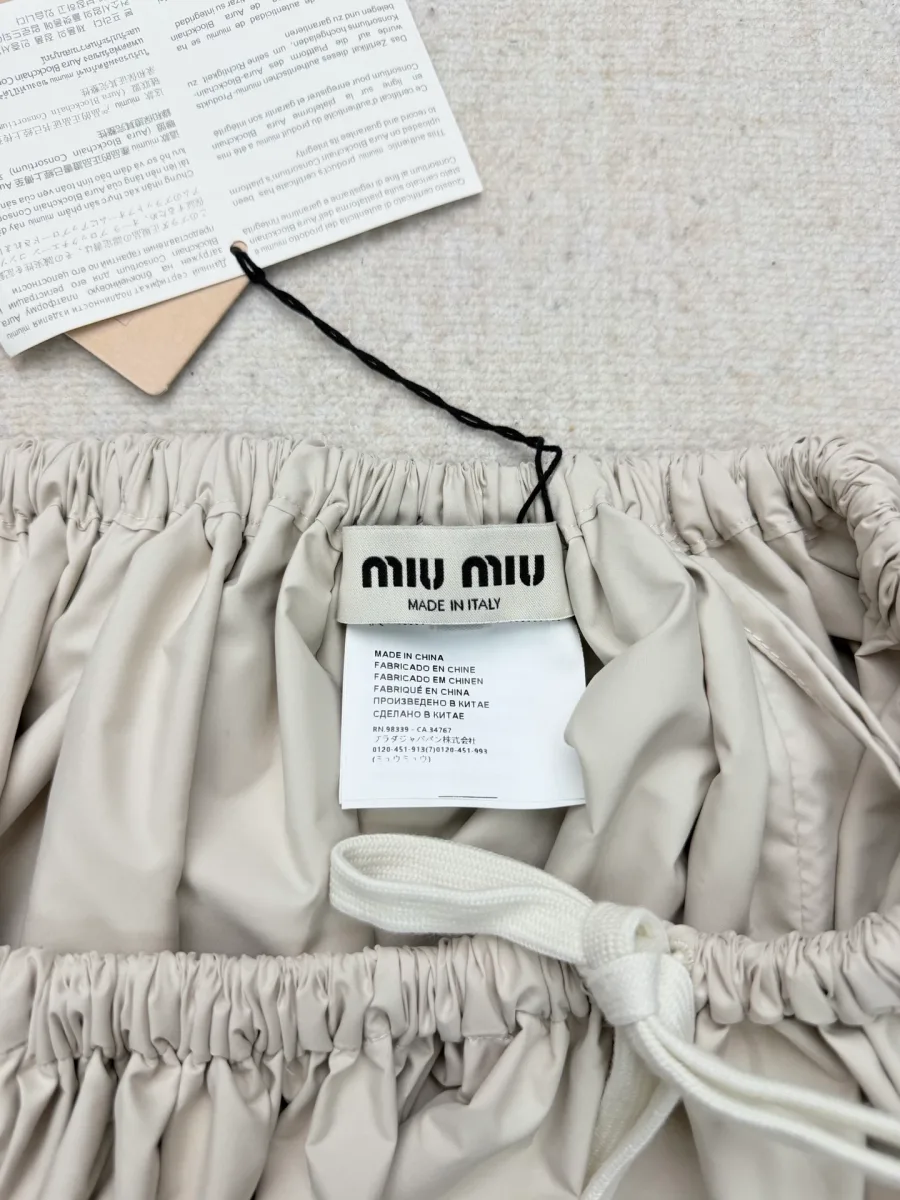 Внутренний ярлык с логотипом Miu Miu и бирки на поясе юбки крупным планом