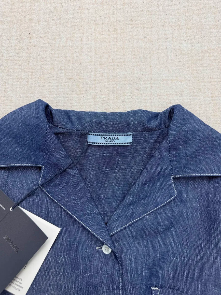 Отложной воротник джинсового комбинезона с фирменной биркой Prada