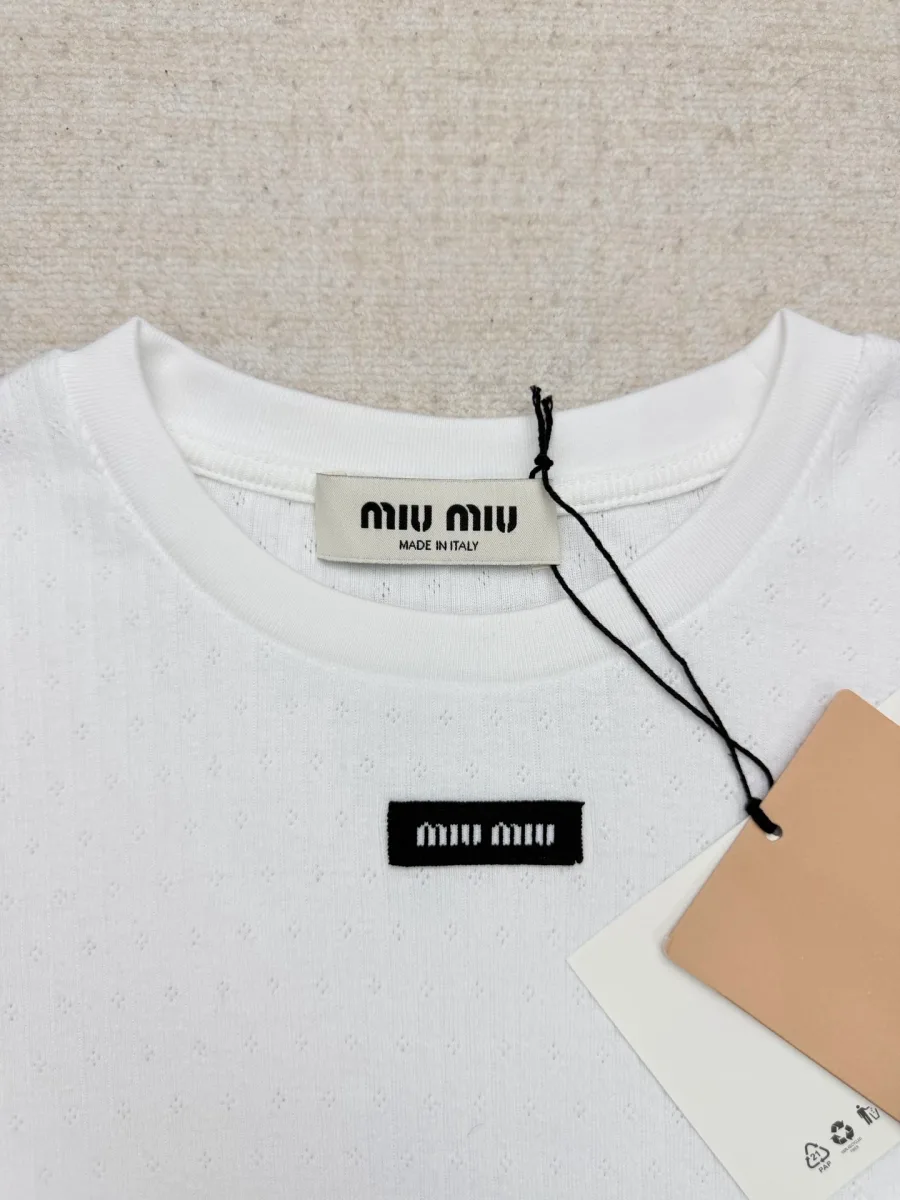 Круглый вырез горловины и черная нашивка с логотипом Miu Miu крупным планом
