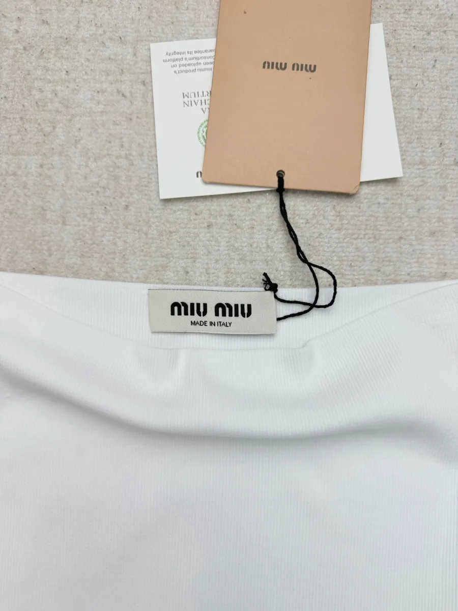 Внутренняя бирка бренда Miu Miu на вырезе платья, макросъемка