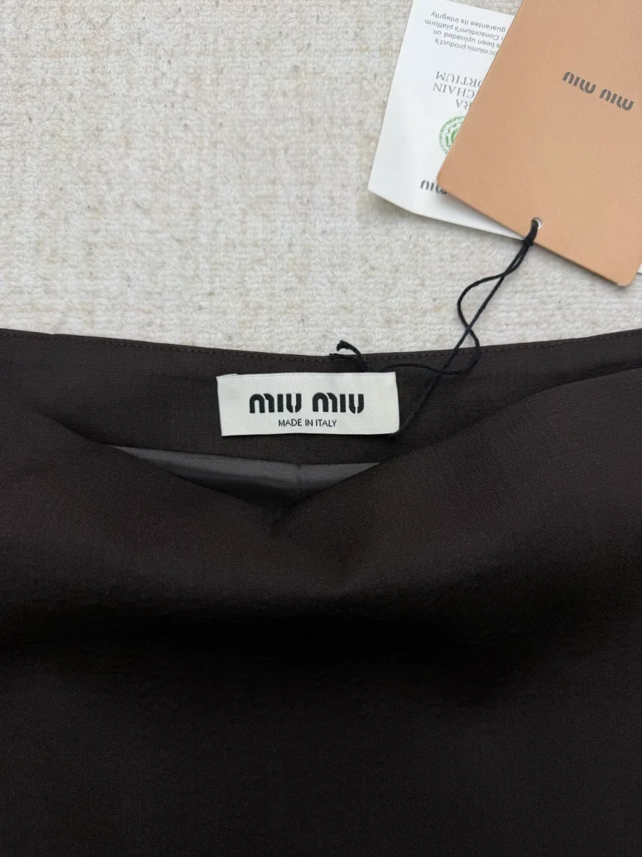 Бирка бренда Miu Miu на внутренней стороне пояса тёмно-коричневой юбки