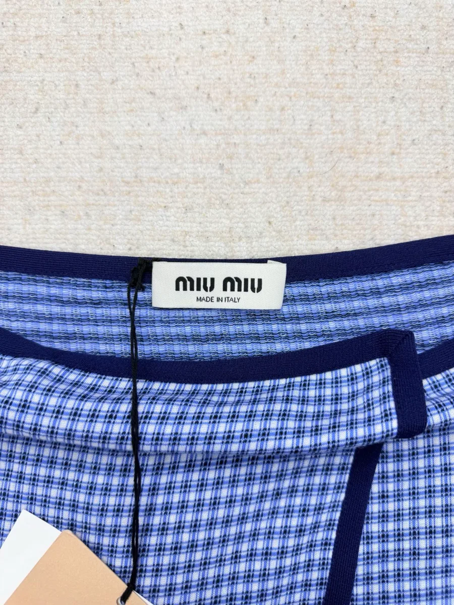 Бирка с логотипом Miu Miu на внутреннем темно-синем поясе юбки