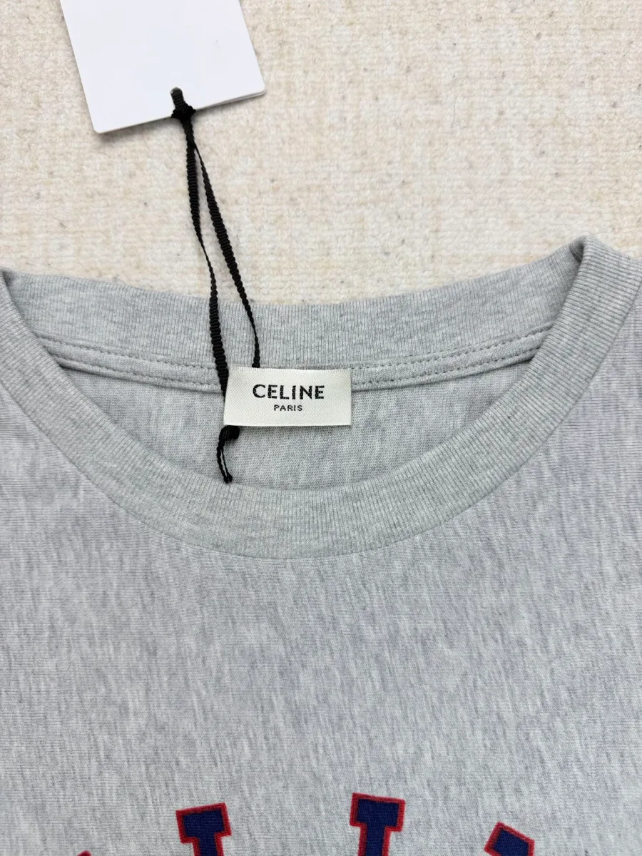 Круглый вырез горловины серой футболки с биркой бренда Celine крупным планом