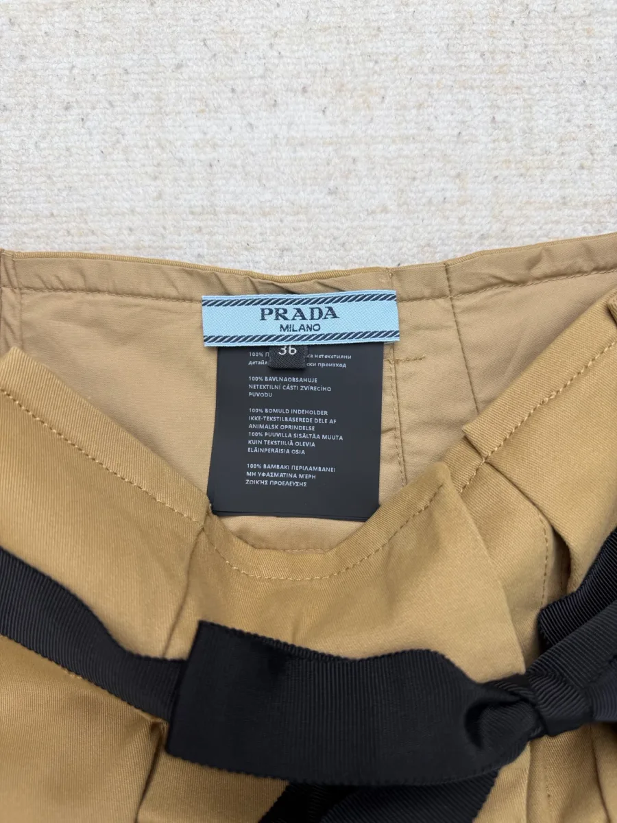 Тканевая бирка Prada Milano с деталями на внутренней стороне пояса бежевой юбки