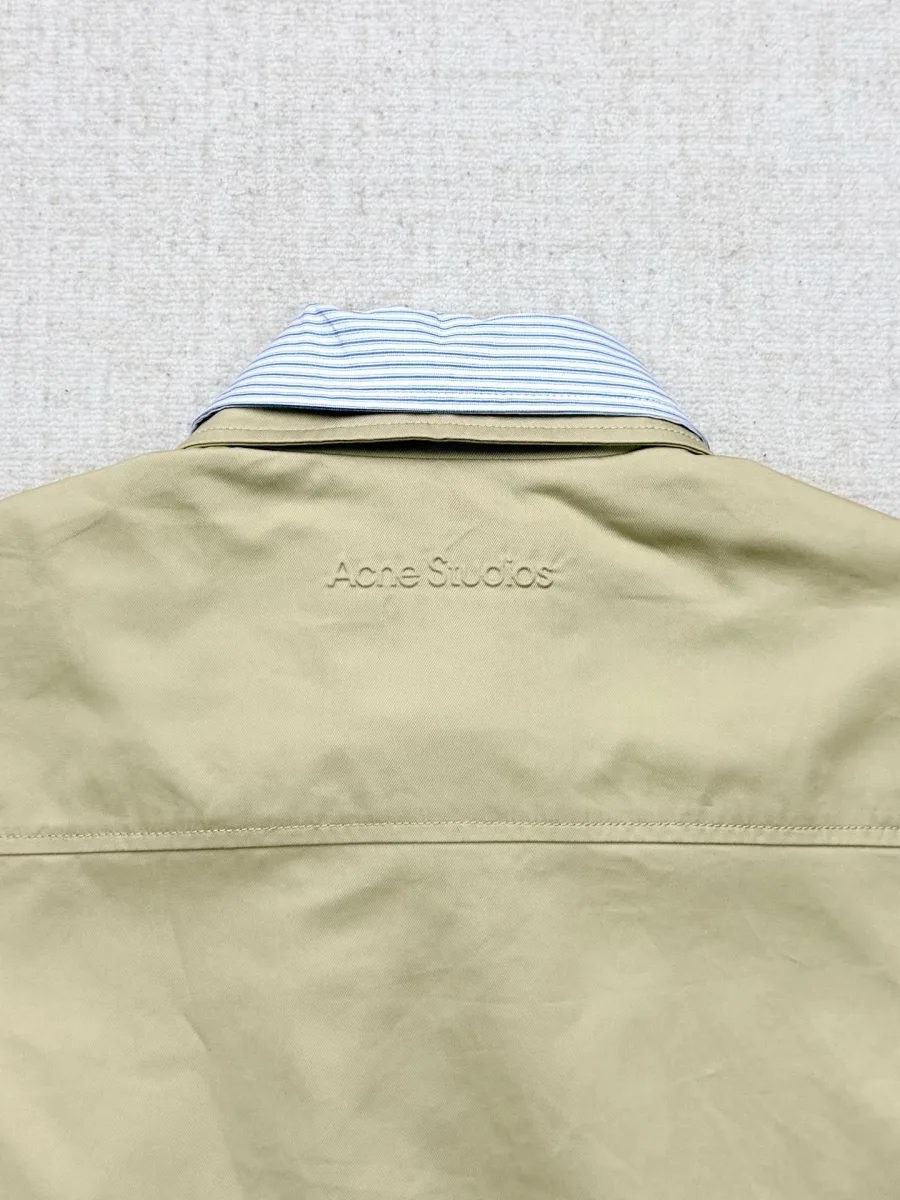 Тиснёный фирменный логотип Acne Studios на спинке куртки крупным планом