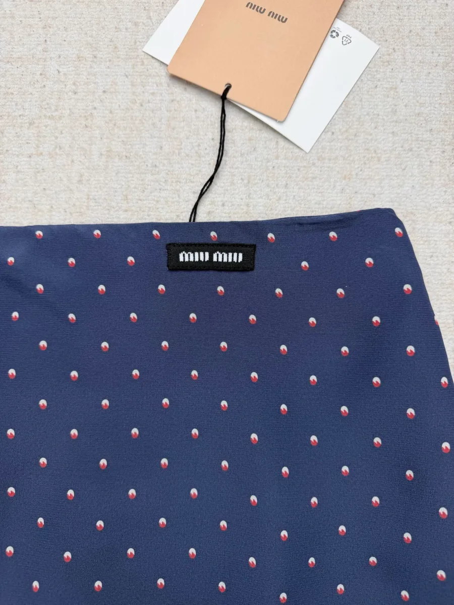 Пояс синей юбки с фирменной нашивкой логотипа Miu Miu