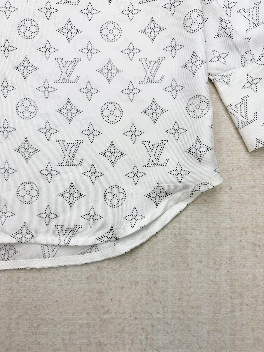 Нижний закругленный край белой шелковой рубашки с узором Monogram
