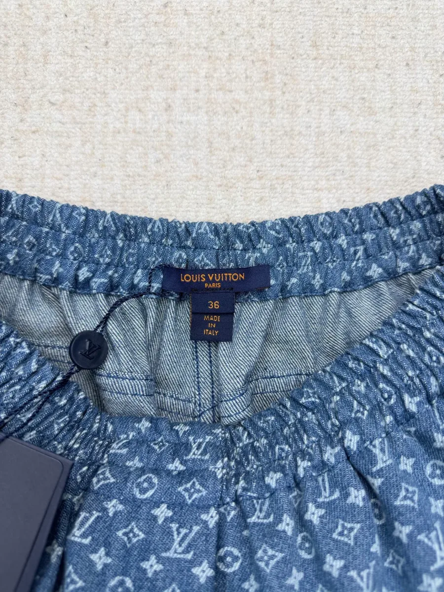 Эластичный пояс шорт с фирменной биркой Louis Vuitton крупным планом