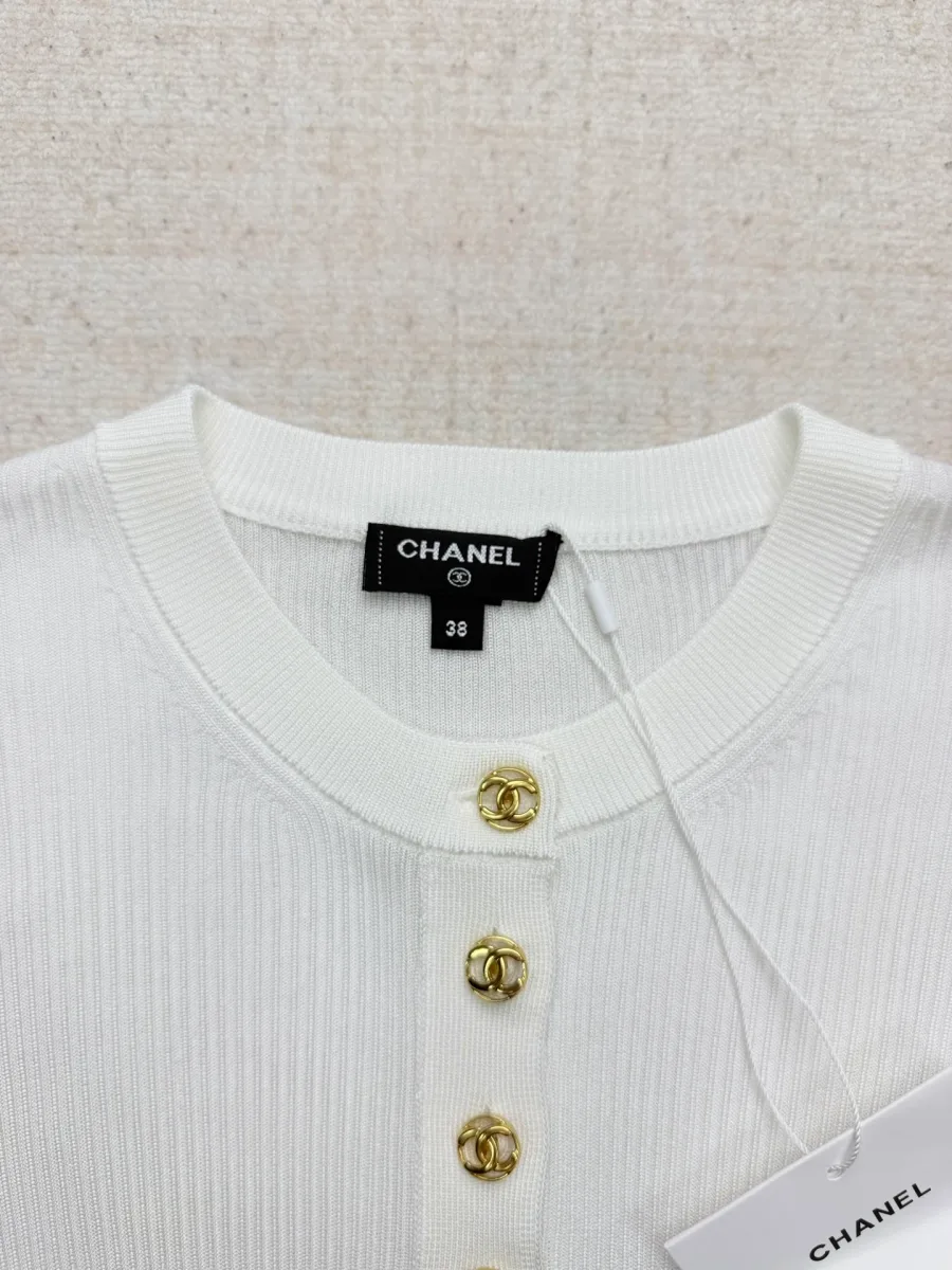 Круглый вырез горловины и верхняя часть планки с золотистыми пуговицами с логотипом