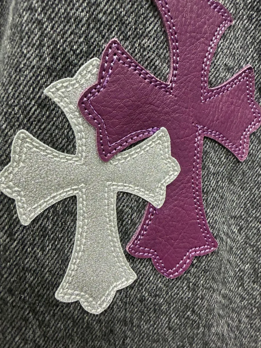 Деталь нашивок-крестов из фиолетовой и серебристой кожи на джинсах Chrome Hearts x Levi's