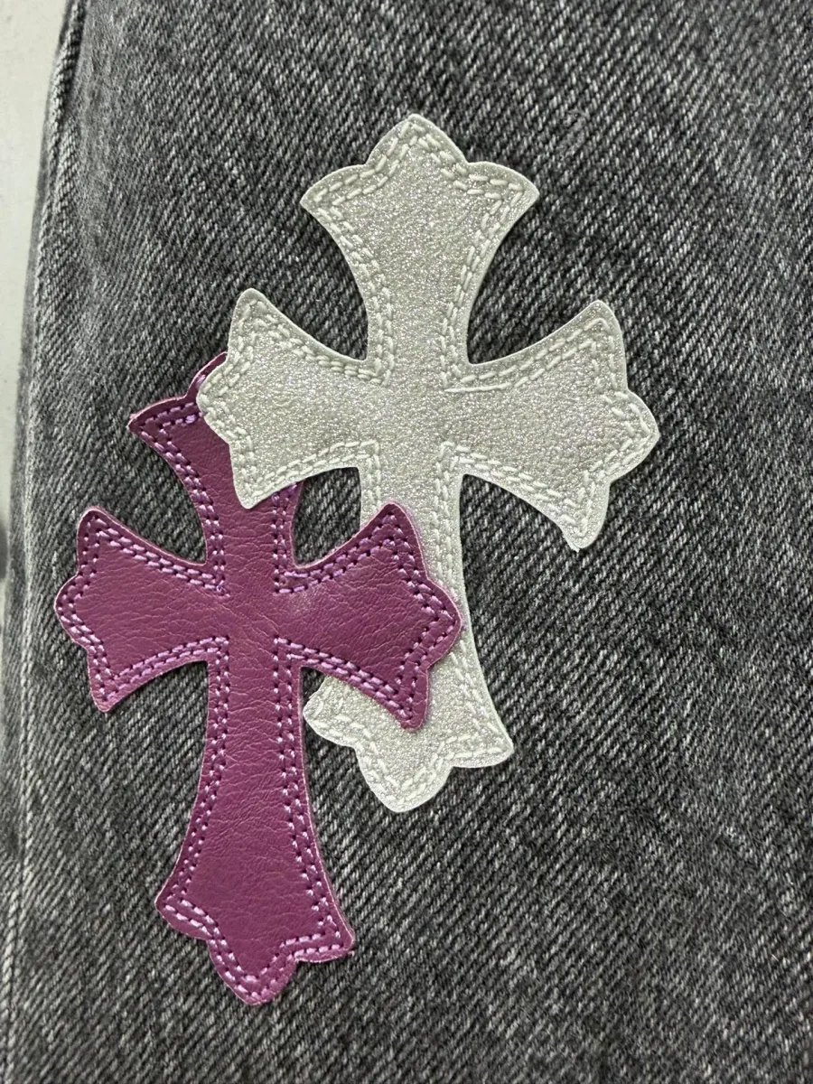 Крупный план кожаных нашивок в виде крестов Chrome Hearts на сером дениме