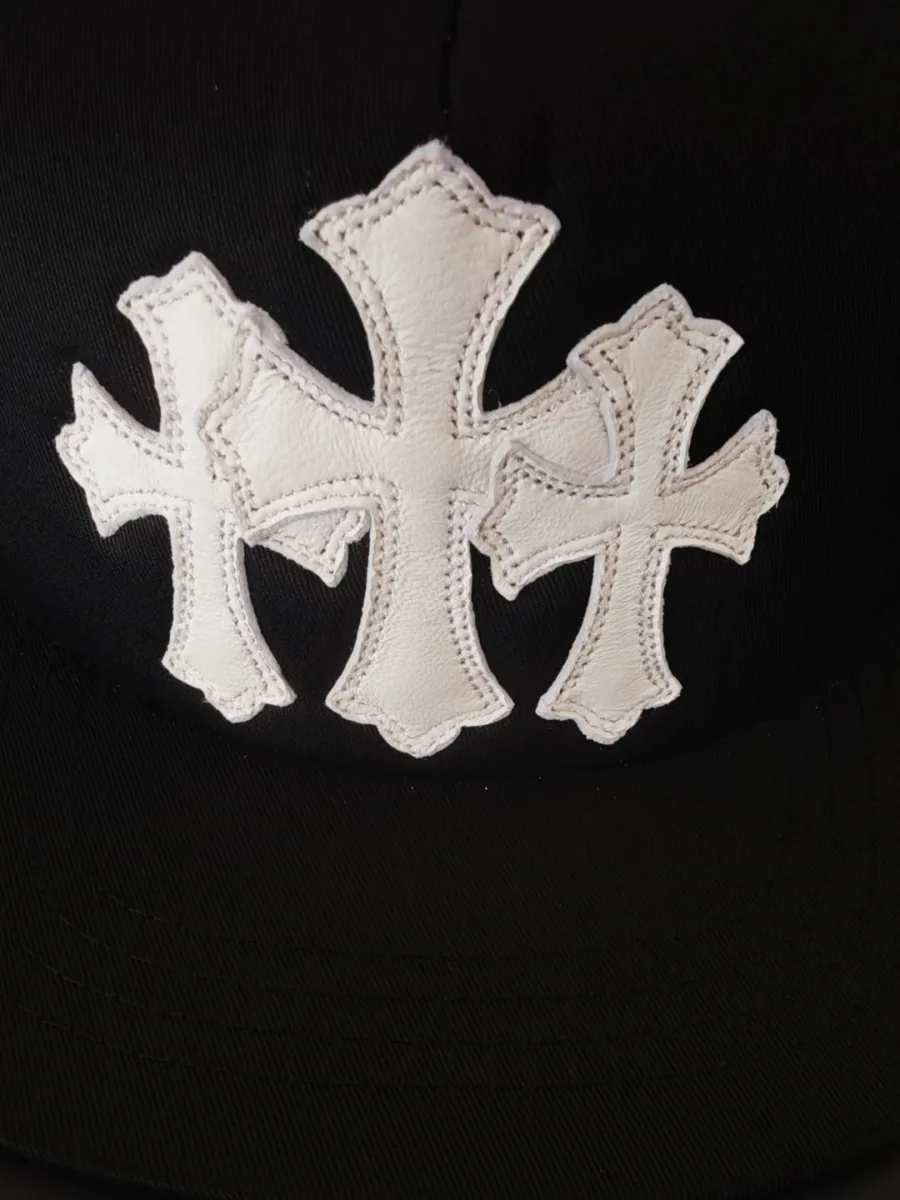Деталь черной бейсболки Chrome Hearts с белыми кожаными патчами
