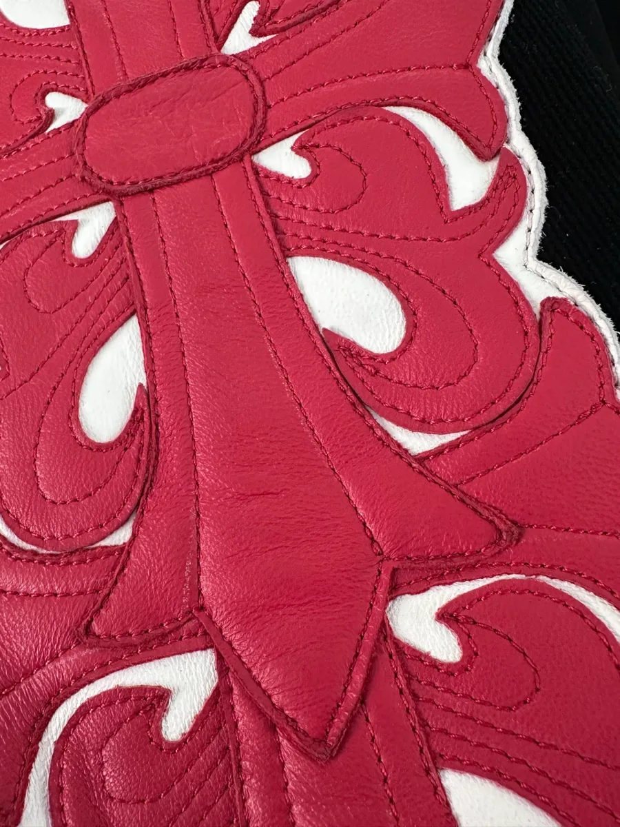 Деталь кожаной нашивки в виде креста на рукаве куртки Chrome Hearts