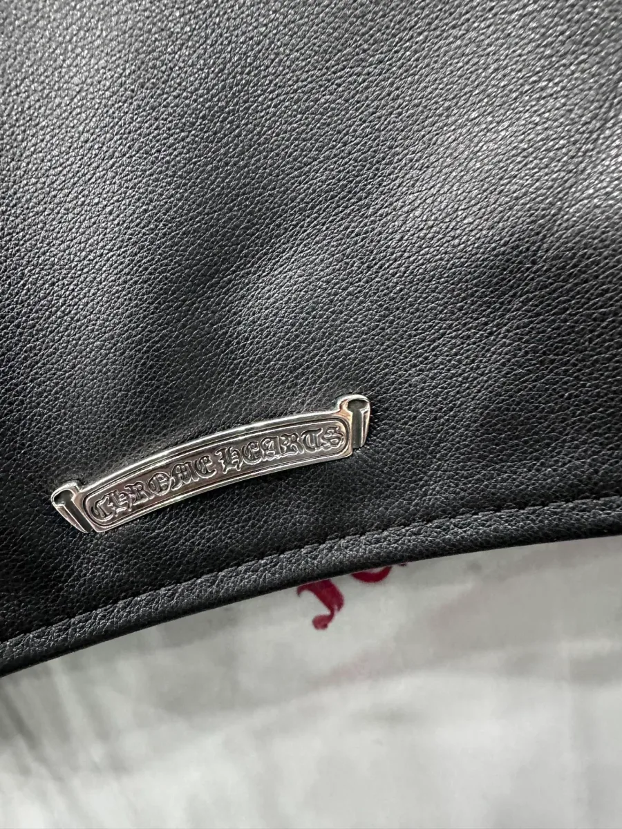 Серебряная пластина с логотипом Chrome Hearts на кожаной куртке