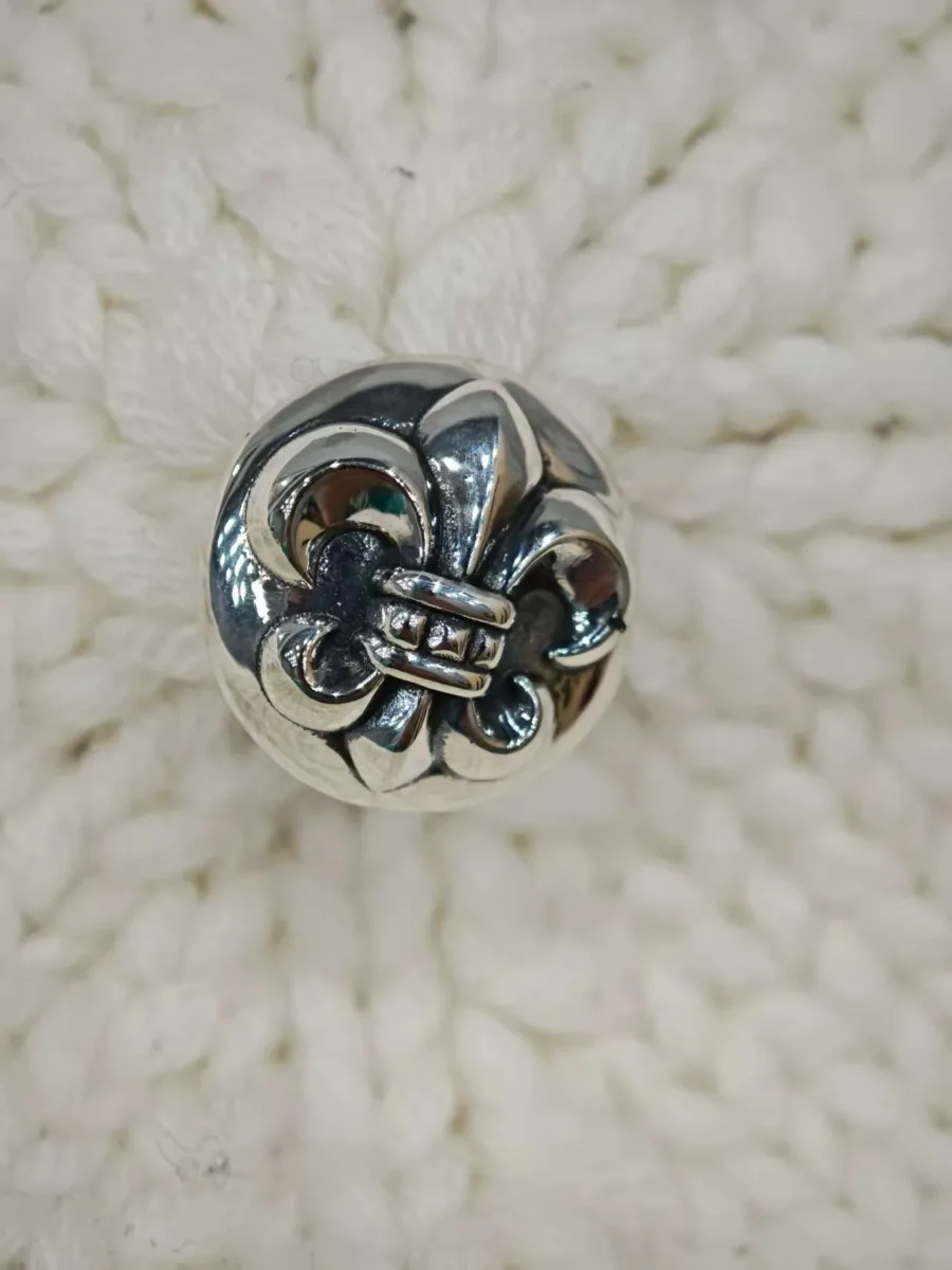 Серебряная кнопка на макушке шапки Chrome Hearts крупным планом