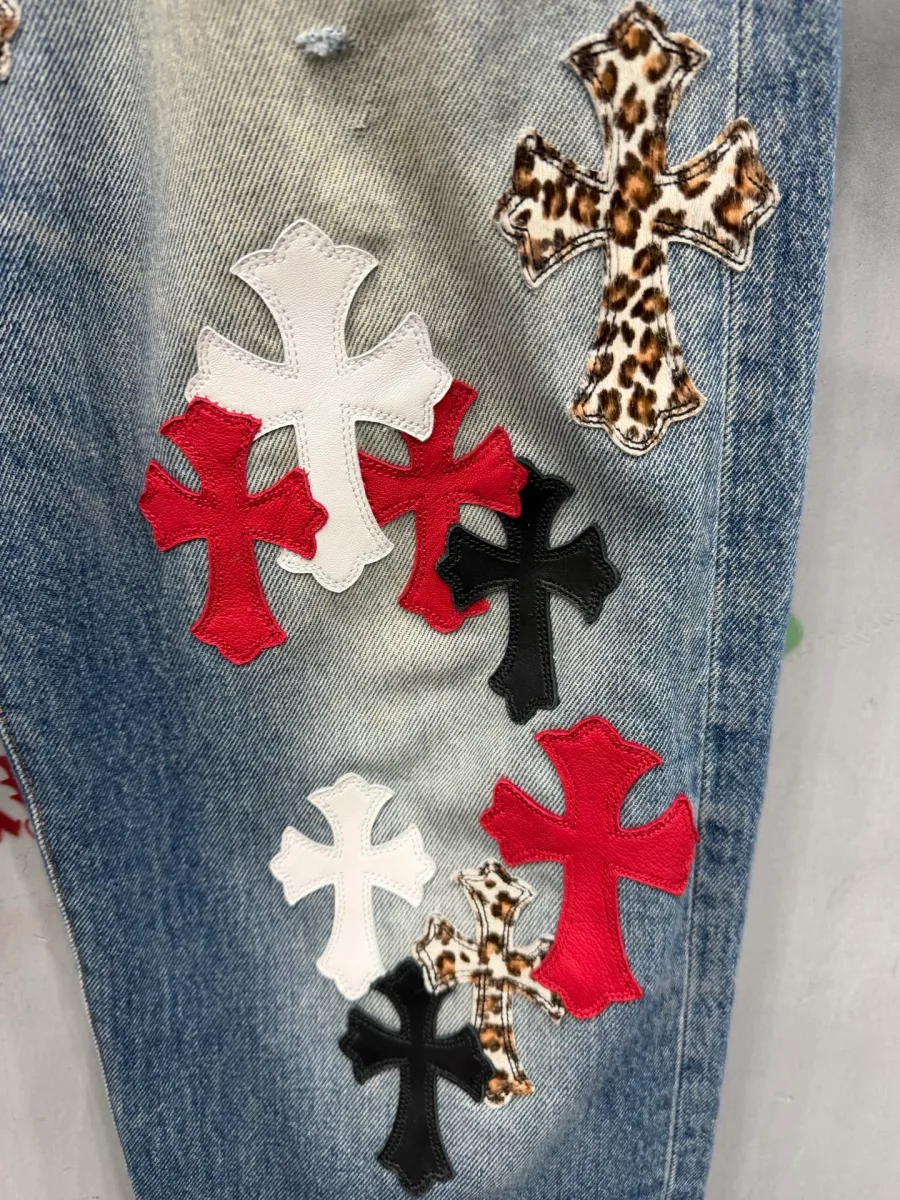 Крупный план кожаных нашивок-крестов на штанине джинсов Chrome Hearts x Levi's