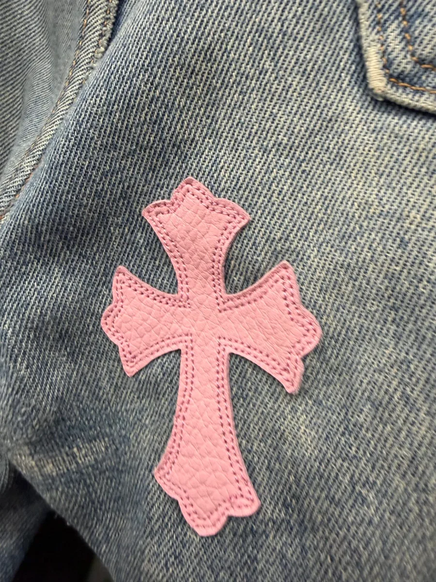 Розовая кожаная нашивка в виде креста на джинсах Chrome Hearts x Levi's