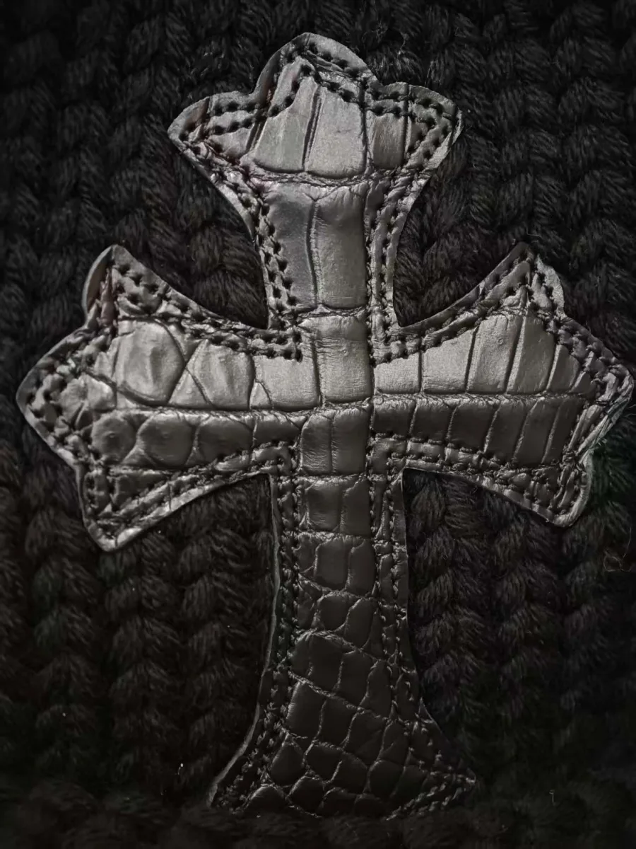 Крупный план нашивки в виде креста из кожи крокодила на шапке Chrome Hearts